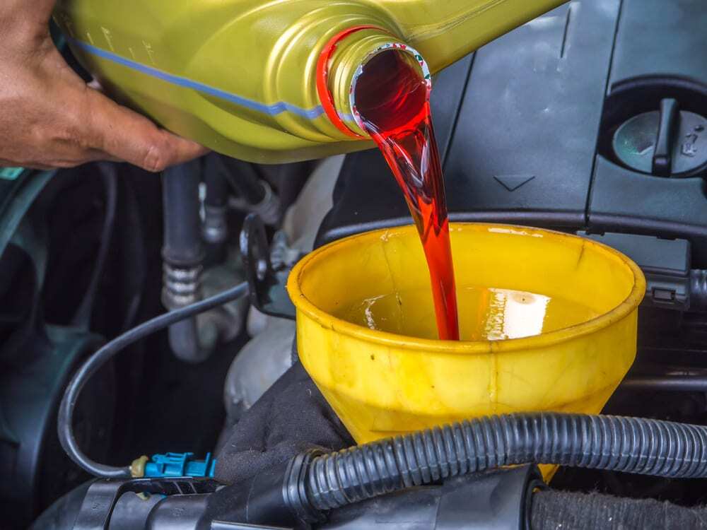 fluid being poured into the engine of a trailer truck