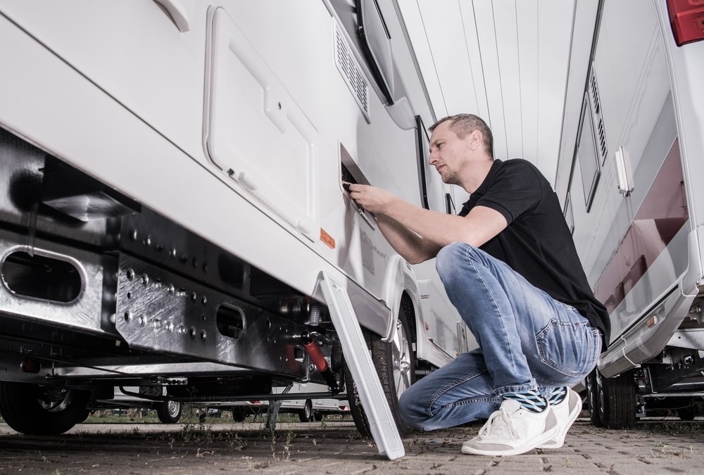 mechanic checking the side of the trailer truck