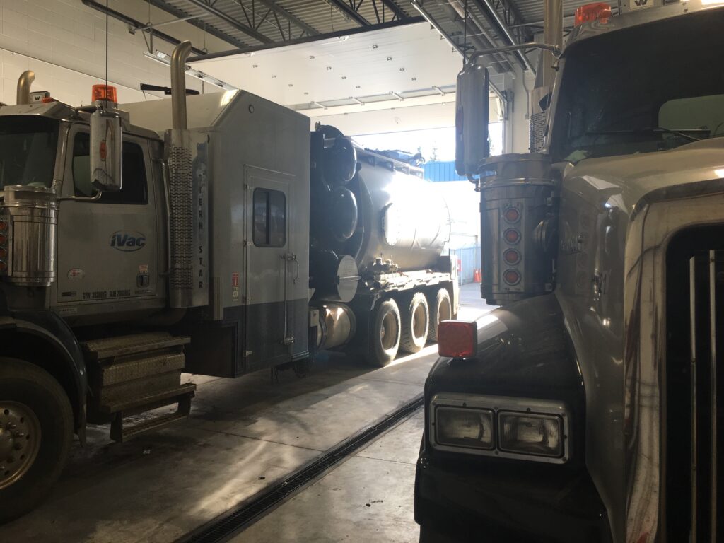 trailer truck besides another trailer truck in a repair facility